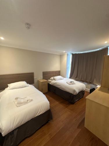 a hotel room with two beds and a window at Cavendish Hotel in High Wycombe
