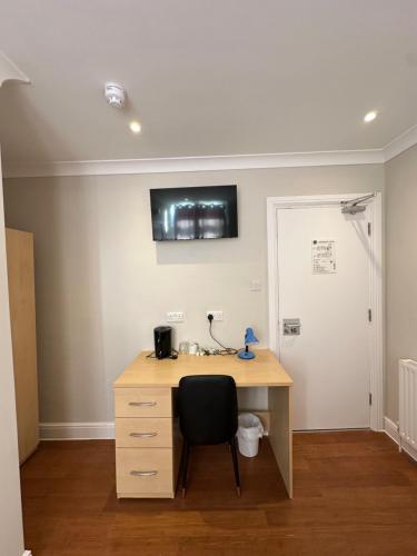 a desk with a chair in a room at Cavendish Hotel in High Wycombe