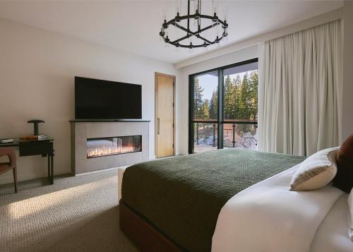 a bedroom with a bed with a fireplace and a tv at Limelight Mammoth in Mammoth Lakes