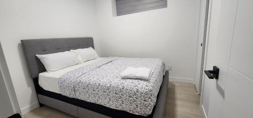 a bedroom with a bed with a black and white comforter at Winnipeg Airport & Polo Park Suites in Winnipeg
