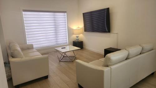 a living room with two chairs and a table at Winnipeg Airport & Polo Park Suites in Winnipeg
