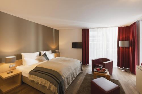 a hotel room with a bed and a chair at Skihotel Galzig B&B in Sankt Anton am Arlberg