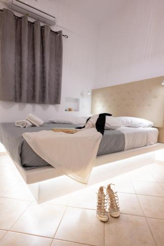 a bedroom with a bed and two pairs of shoes at Little Yard Studios & Apartments #4 in Naxos Chora