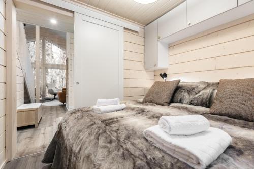 a bedroom with a large bed with two white pillows at Villa Mokum by PolarVillas in Kittilä