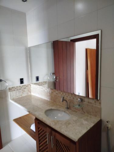 a bathroom with a sink and a mirror at Varanda das Palmeiras in Cairu