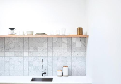 eine Küchenarbeitsplatte mit Spüle und Regal in der Unterkunft Bask & Stow I Luxe Guesthouse in Byron Bay