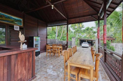 an outdoor dining area with a wooden table and chairs at Kelingking Terrace Cottage in Nusa Penida
