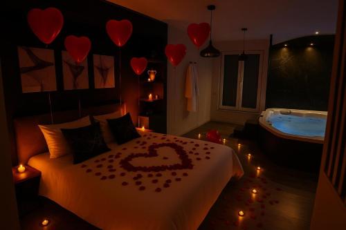 a bedroom with a bed and a tub with hearts on it at CK Suite & Spa - Jacuzzi Privatif - Reims in Reims