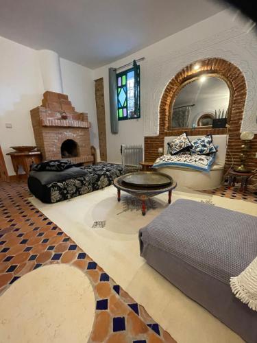 a living room with a bed and a fireplace at Dar fenan Lina in Chefchaouen