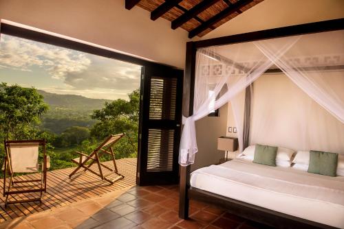 a bedroom with a bed and a balcony with a view at El Respiro Ecolodge in Granada