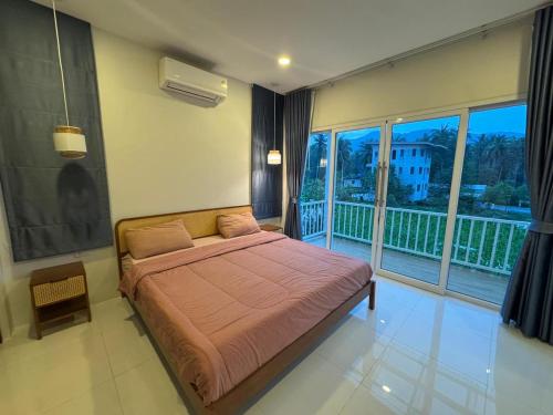 a bedroom with a bed and a balcony at Villa Solara in Ko Phangan