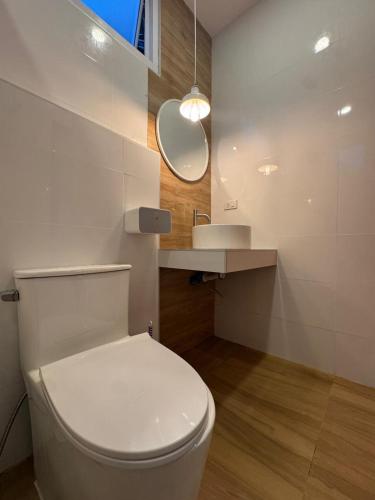 a bathroom with a white toilet and a sink at Villa Solara in Ko Phangan