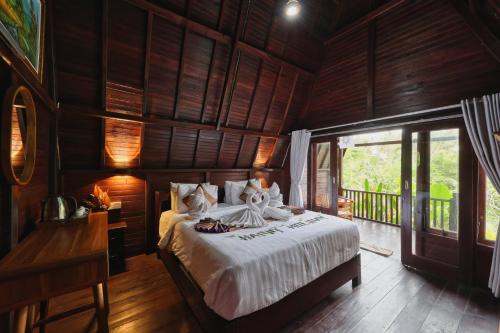 a bedroom with a bed in a room with wooden walls at Kelingking Terrace Cottage in Nusa Penida