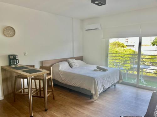 a bedroom with a bed and a desk and a table at L&J Loft 1 ambiente in Belén de Escobar