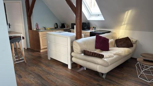 a living room with a white couch and a kitchen at FeWo ,Sonnenschein ,Sollstedt in Sollstedt