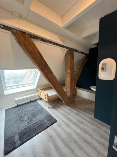 an attic room with wooden beams and a rug at Pension Veldzigt in Wijnaldum