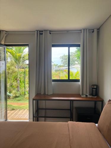 a bedroom with a bed and a window with curtains at Oby Noronha in Fernando de Noronha