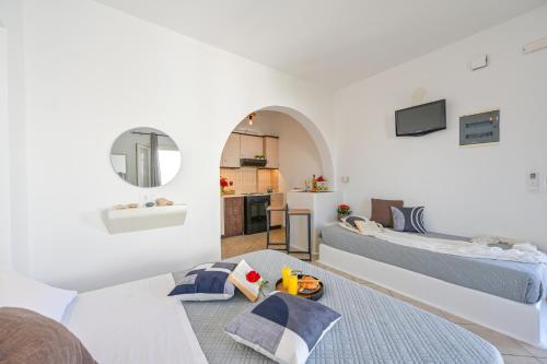 a white living room with two beds and a table at Little Yard Studios & Apartments #6 in Naxos Chora