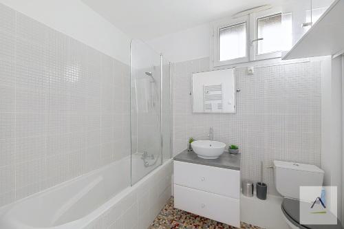 une salle de bains blanche avec un lavabo et des toilettes dans l'établissement L'Odorico, à Rennes