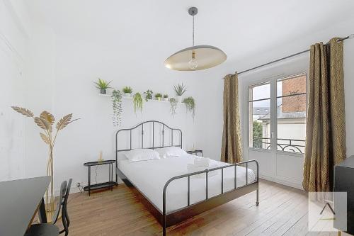 une chambre blanche avec un lit et une fenêtre dans l'établissement L'Odorico, à Rennes
