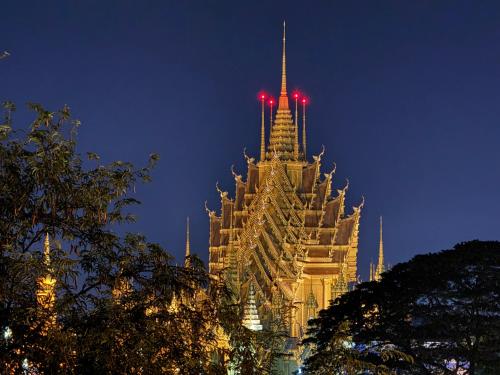 a large building with red lights on top at night at Little Jasmine by the River in Phitsanulok