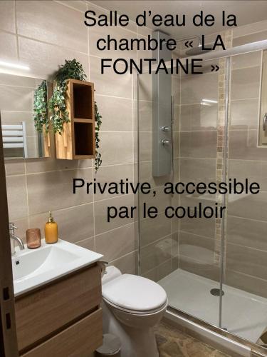 a bathroom with a toilet and a sink and a shower at Les Eaux Vives in Manaurie