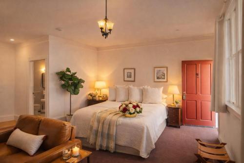 a bedroom with a bed with a flower arrangement on it at Tomales Hotel, Minutes from Dillon Beach in Tomales