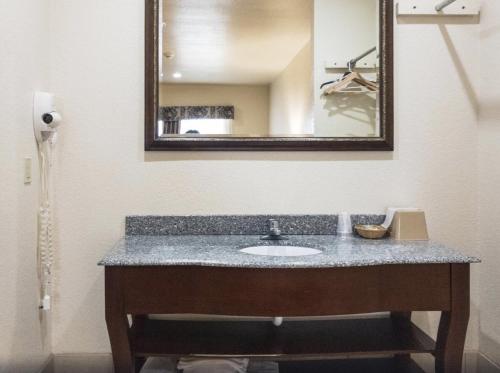 a bathroom with a sink and a mirror at HiWay Inn Express in Coalgate