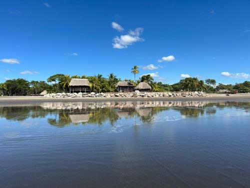 a beach with chairs and buildings and the water at The Chill Inn in Jiquilillo