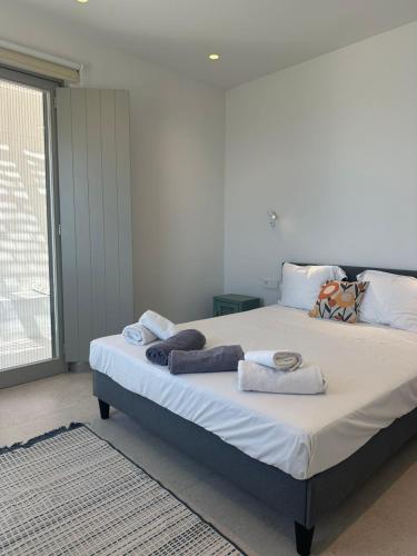 a bedroom with a large bed with towels on it at Aetheria Apartment with Private Pool in Kampos Paros