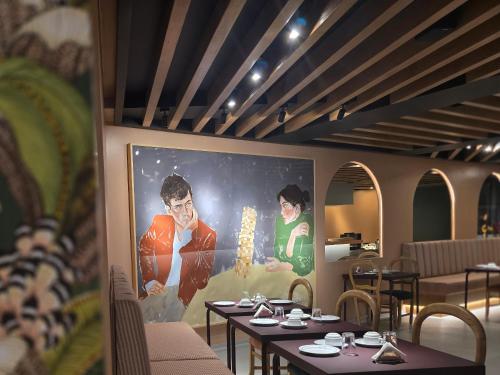 a restaurant with tables and a large painting on the wall at ASPA Studios - Urban Conscious Living in Funchal