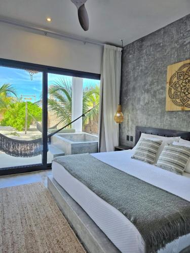 a bedroom with a bed and a view of the ocean at Casa del Mar Holbox in Holbox Island
