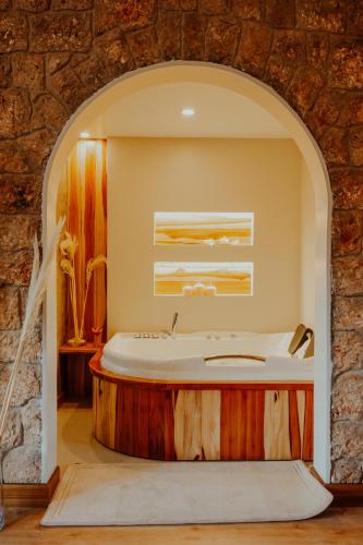 un bagno con vasca da bagno in un muro di pietra di Hosteria Duran a Cuenca