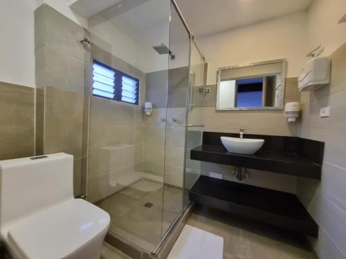 a bathroom with a toilet and a sink and a shower at Hotel campestre La Floresta in Armenia