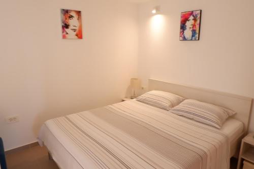 a bed in a room with two pictures on the wall at Apartment Marija in Premantura