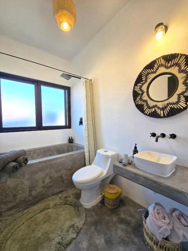 a bathroom with a toilet and a sink and a mirror at Casa del Mar Holbox in Holbox Island