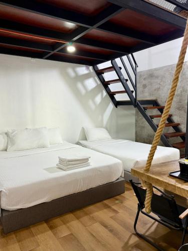two beds in a room with a hammock at Ardour Lodge "A" Wing in Tanjung Bungah