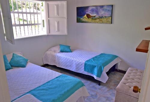 a bedroom with two beds and a window at Hermosa Finca Con Piscina y Jacuzzi in El Peñol