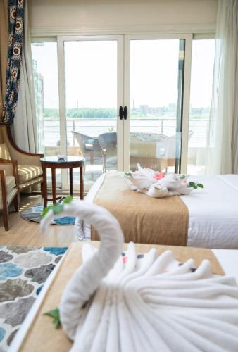 a hotel room with two beds with towels on the floor at Nile Transport Hotel in Cairo