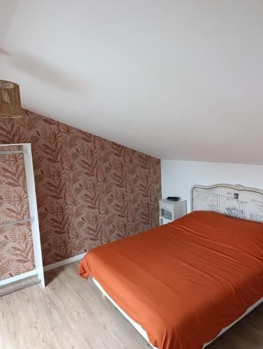 una camera da letto con un letto con una coperta arancione di La Pause Loonoise a Loon-Plage