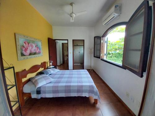 a bedroom with a bed and a window in it at Brisas da Cocanha in Caraguatatuba
