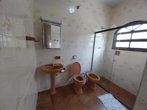 a bathroom with a sink and a toilet and a shower at Brisas da Cocanha in Caraguatatuba