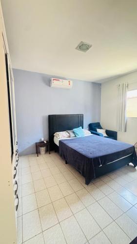 a bedroom with a bed and a tiled floor at Casa com piscina in Paulista