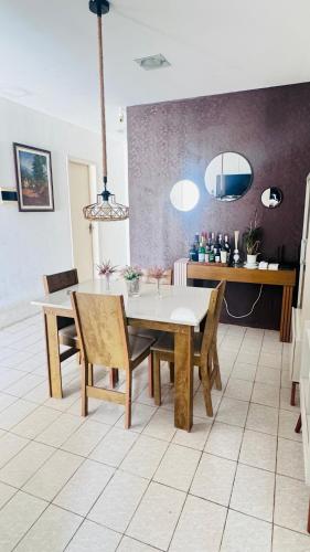 a dining room with a table and chairs at Casa com piscina in Paulista
