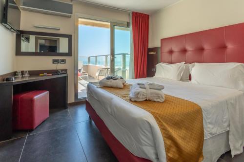 a bedroom with a large bed with towels on it at Terminal Palace & SPA in Rimini