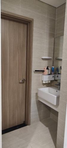 a bathroom with a sink and a wooden door at SHome, căn hộ 55m2,2 phòng ngủ, Oceanpark 1 in Gia Lâm Pho