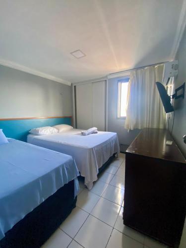 a hotel room with two beds and a window at APARTAMENTO EM NATAL III in Natal