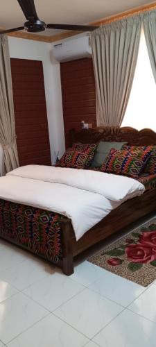 a bedroom with a bed with a wooden frame at Sunset Banana Beach Resort in Prampram