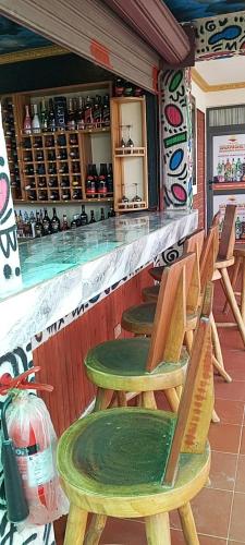 a bar with wooden chairs sitting at a counter at Sunset Banana Beach Resort in Prampram