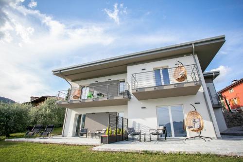 a white house with chairs and a balcony at Dal Ross 2 in Riva di Solto